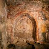All�interno del piccolo arco sono presenti tre figure. Al centro � rappresentato Cristo su di un trono...